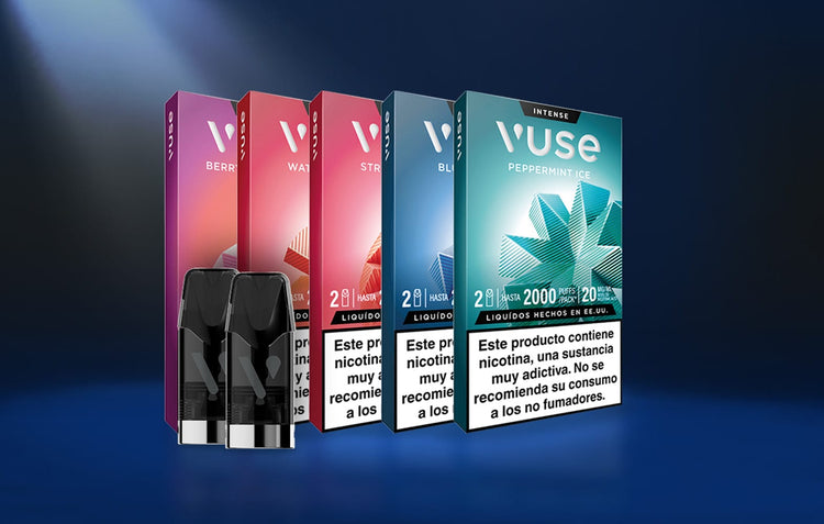 Cinco coloridos paquetes de vapeadores Vuse, cada uno con un sabor distinto, están colocados en fila sobre un fondo azul degradado. Delante se colocan dos cápsulas negras. En cada envase aparecen advertencias sanitarias en español.
