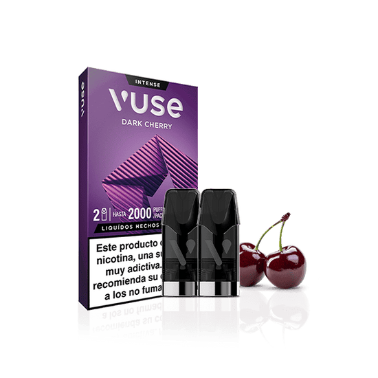 Un paquete de Vuse Pods - Dark Cherry de Vuse, con dos vainas colocadas delante junto a dos cerezas. La caja morada muestra un diseño geométrico y una etiqueta de advertencia de nicotina en español en la parte inferior.