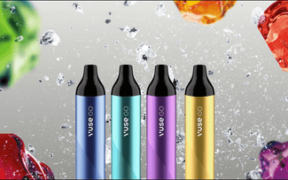 Cuatro bolígrafos para vapear Vuse GO en azul, verde azulado, morado y amarillo se colocan en posición vertical con salpicaduras de líquido y gotas de colores en el fondo.