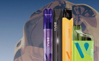 Cuatro coloridos bolígrafos para vapear Vuse GO se muestran en posición vertical sobre un fondo azul con una forma abstracta marrón detrás. Cada bolígrafo tiene un diseño y una combinación de colores diferentes.